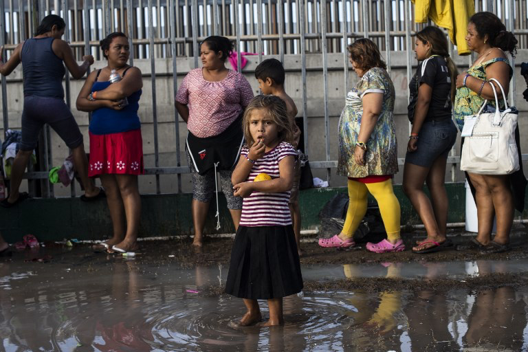 Child standing in water waiting at the US/Mexico Border